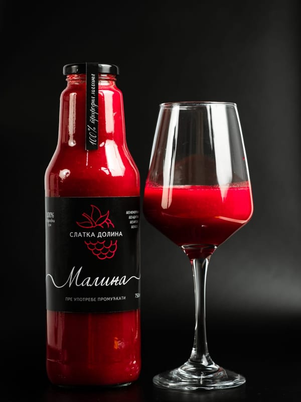 Flaša od 750 ml hladno ceđenog soka od maline sa crnom etiketom i čašom